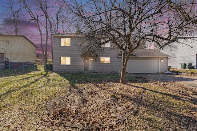 view of front of house featuring a front yard, an attached garage, fence, and driveway