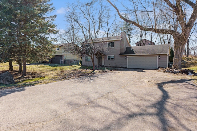 view of front of house with aphalt driveway, an attached garage, and a chimney