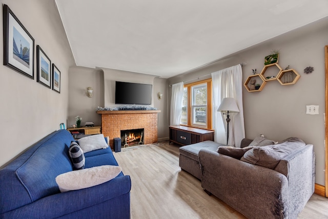 living room featuring light wood-style flooring and a fireplace