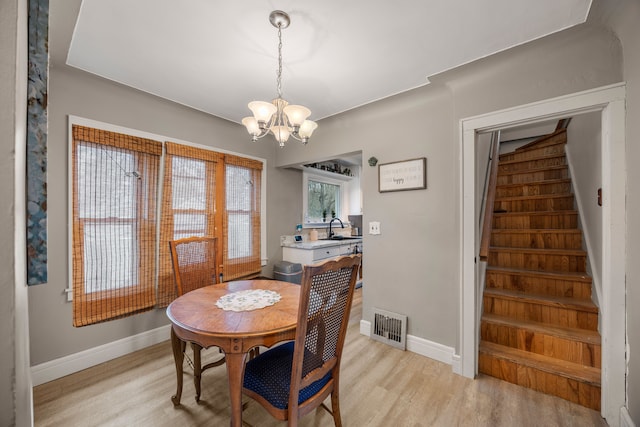 dining area featuring baseboards, visible vents, stairs, a notable chandelier, and light wood-type flooring