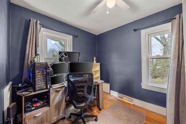 office with visible vents, a healthy amount of sunlight, baseboards, and wood finished floors