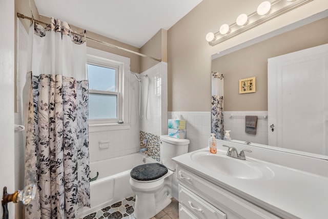 full bathroom featuring toilet, vanity, wainscoting, shower / bath combination with curtain, and tile walls