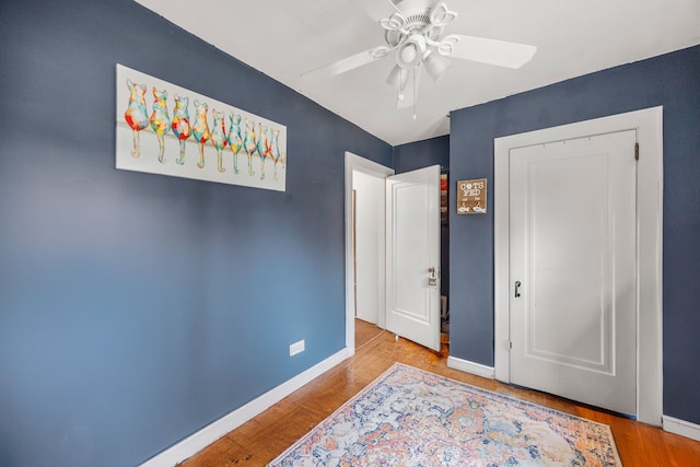 bedroom featuring ceiling fan, baseboards, and wood finished floors