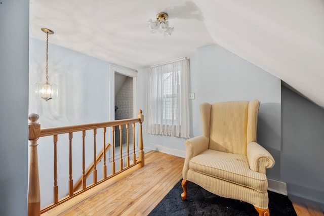 living area with baseboards, an upstairs landing, lofted ceiling, and wood finished floors