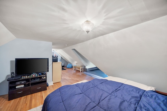 bedroom with vaulted ceiling and wood finished floors