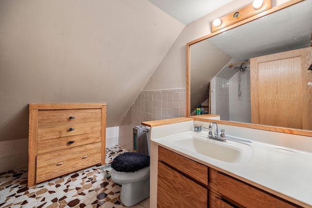 full bathroom featuring vanity, lofted ceiling, walk in shower, tile walls, and toilet