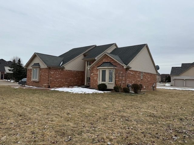 ranch-style house with brick siding and a front yard