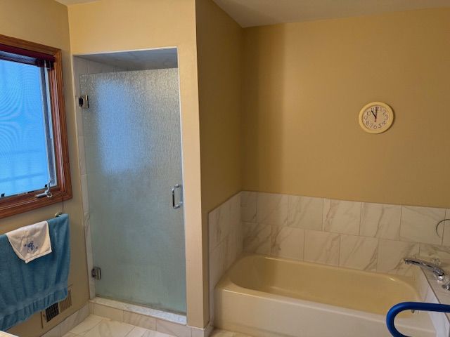 bathroom with a bath and a stall shower