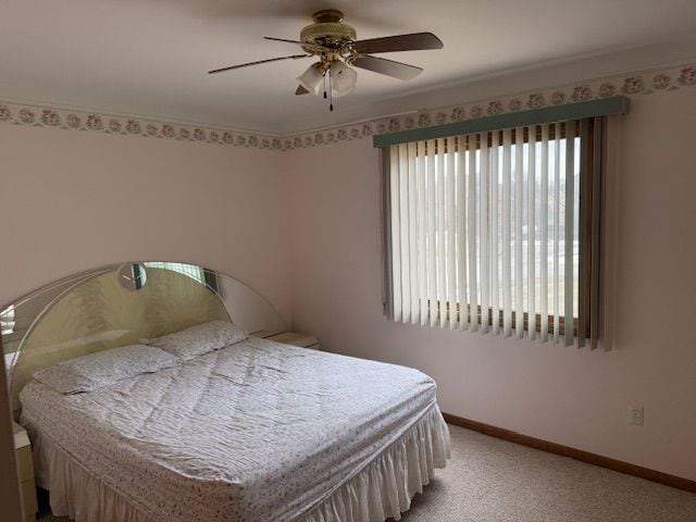 bedroom featuring baseboards, light carpet, and ceiling fan