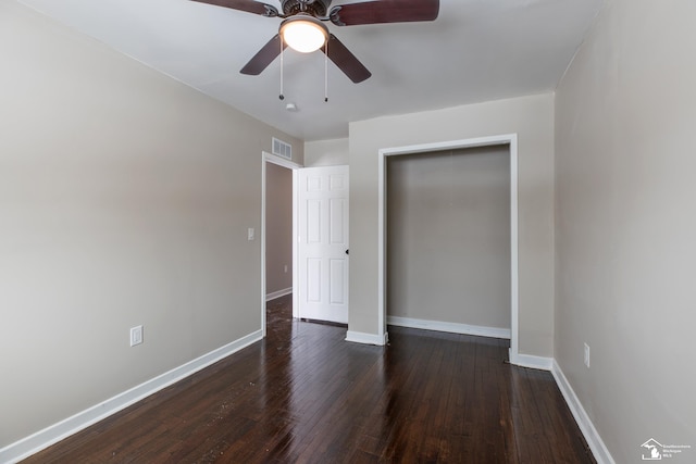 unfurnished bedroom featuring dark wood finished floors, visible vents, baseboards, and ceiling fan