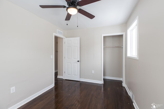 unfurnished bedroom with visible vents, baseboards, a closet, and dark wood-style flooring