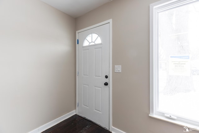 entrance foyer with dark wood-style floors and baseboards