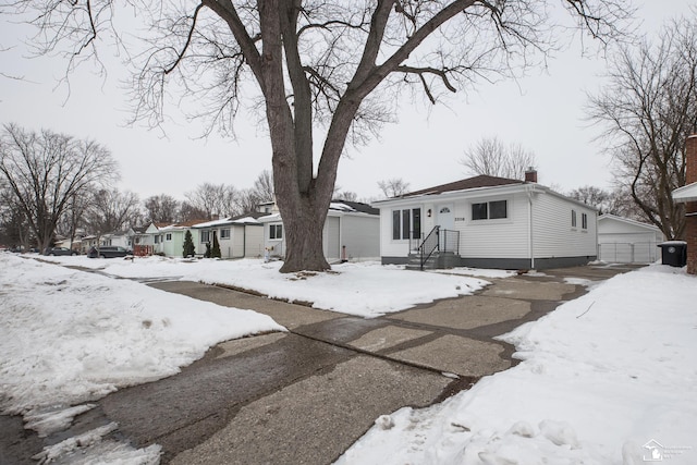 view of front of property featuring a garage, an outbuilding, and a chimney