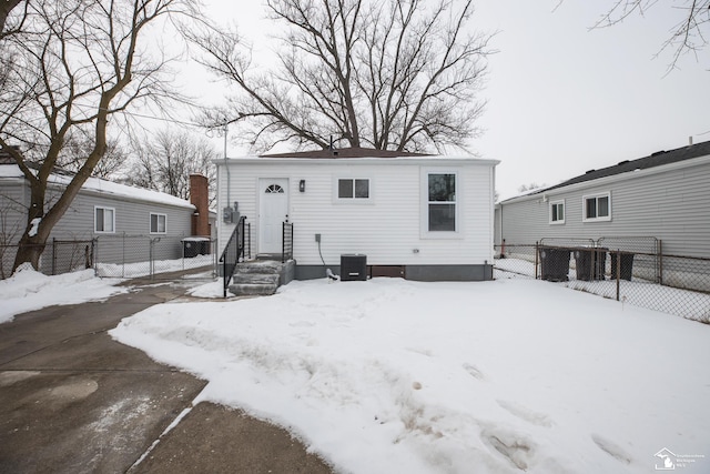 snow covered rear of property with fence