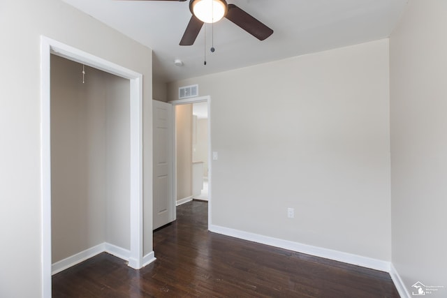 interior space featuring visible vents, baseboards, a ceiling fan, and dark wood-style flooring