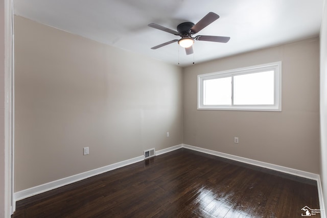 empty room featuring visible vents, baseboards, a ceiling fan, and dark wood-style flooring