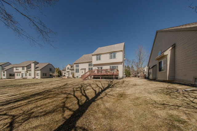 rear view of property featuring a yard, a residential view, and a deck