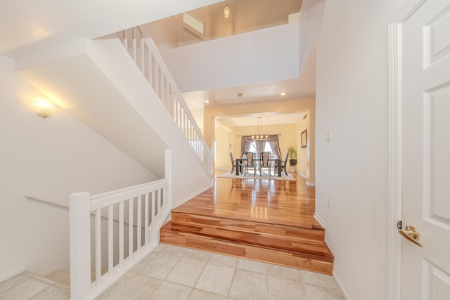 interior space with baseboards, an inviting chandelier, and stairs