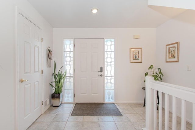 entrance foyer with light tile patterned flooring and baseboards