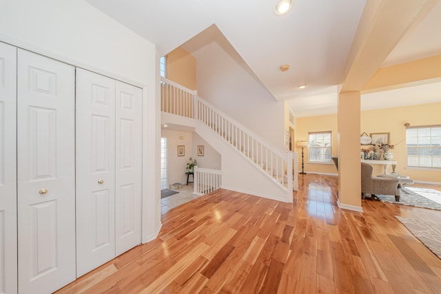 foyer entrance featuring baseboards, light wood-style flooring, and stairs