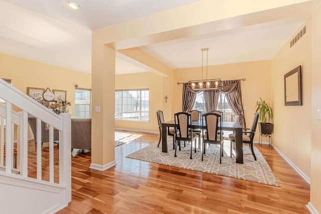 dining space with a chandelier, visible vents, light wood-style flooring, and baseboards