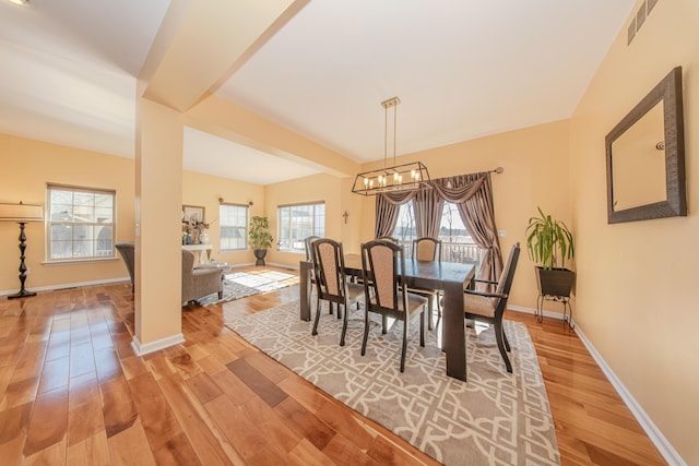 dining room featuring visible vents, baseboards, light wood-style floors, and an inviting chandelier