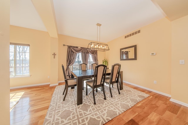 dining area featuring a notable chandelier, visible vents, a healthy amount of sunlight, and light wood finished floors