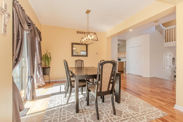 dining room featuring an inviting chandelier, light wood-style floors, baseboards, and a wealth of natural light