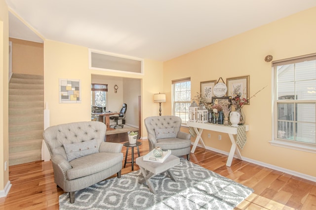 sitting room featuring baseboards, wood finished floors, and stairs