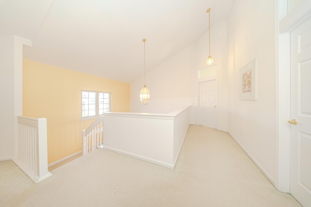 hall featuring an upstairs landing, baseboards, light carpet, and lofted ceiling