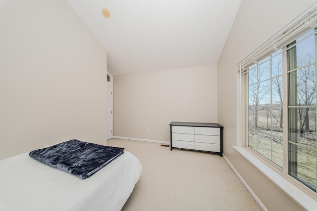 carpeted bedroom featuring lofted ceiling and baseboards