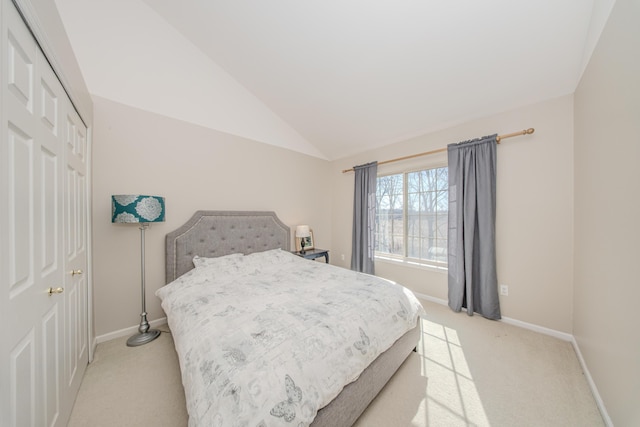 bedroom with light carpet, a closet, baseboards, and vaulted ceiling