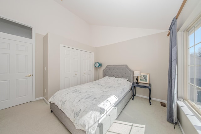 carpeted bedroom with a closet, visible vents, baseboards, and vaulted ceiling