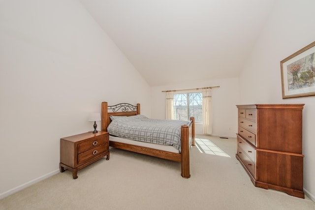 bedroom with light colored carpet, baseboards, and lofted ceiling