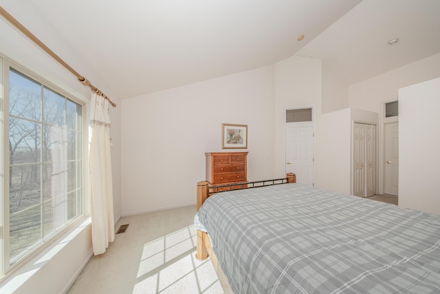 bedroom with high vaulted ceiling, baseboards, visible vents, and light carpet