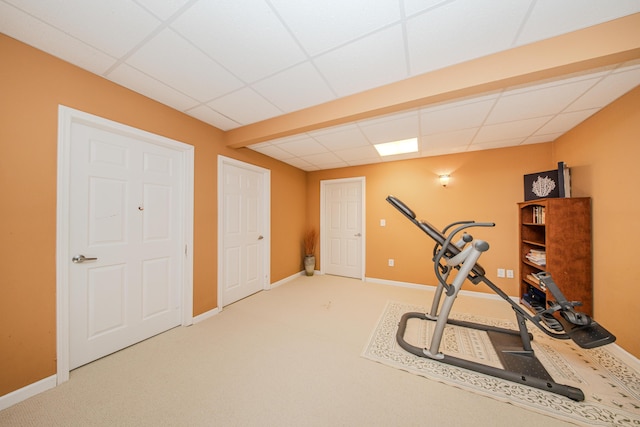 exercise room featuring a drop ceiling, baseboards, and carpet flooring