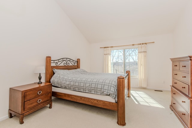 bedroom featuring visible vents, light colored carpet, baseboards, and vaulted ceiling