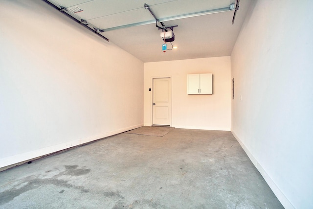 garage featuring a garage door opener and baseboards