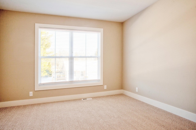 unfurnished room featuring visible vents, carpet flooring, and baseboards