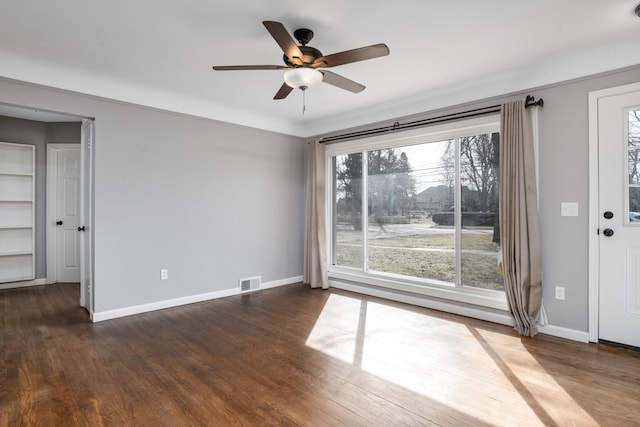 empty room with visible vents, plenty of natural light, baseboards, and dark wood-style flooring