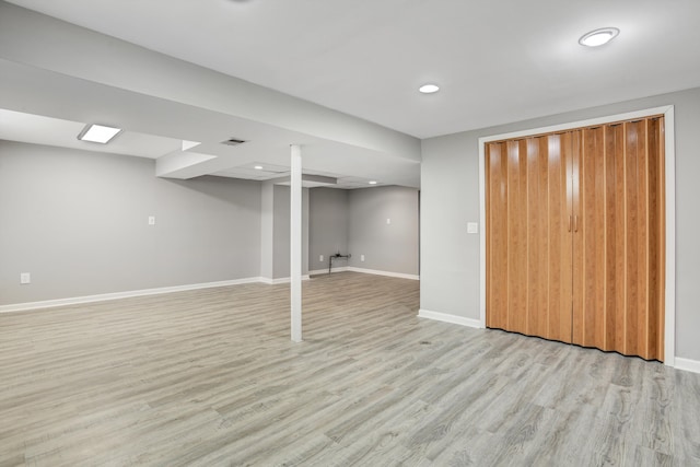 finished below grade area featuring light wood finished floors, visible vents, recessed lighting, and baseboards