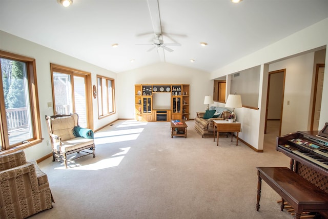 living area featuring lofted ceiling, carpet flooring, a ceiling fan, and baseboards