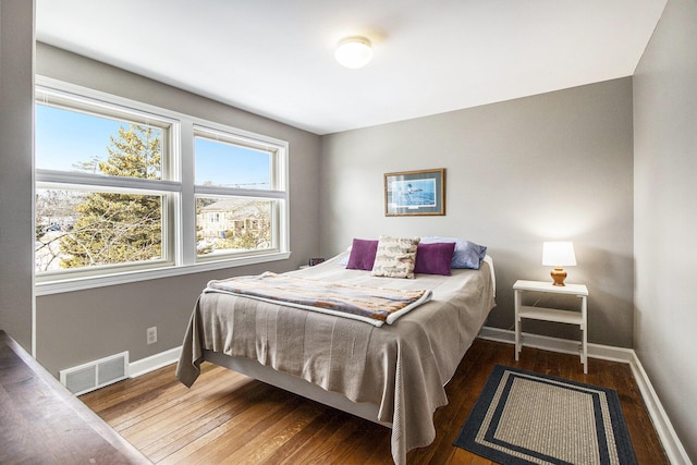 bedroom featuring visible vents, baseboards, and hardwood / wood-style flooring