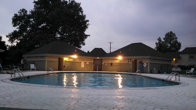 pool with a patio area and fence