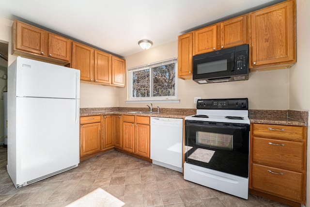 kitchen with brown cabinets, white appliances, and a sink