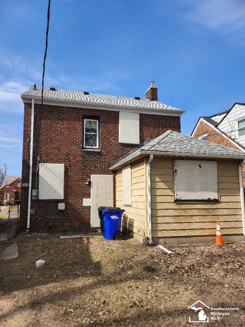 view of side of home featuring brick siding and a chimney