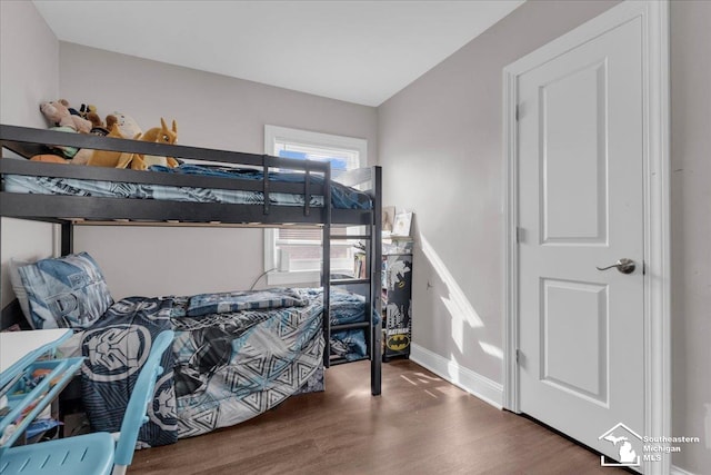 bedroom with baseboards and wood finished floors