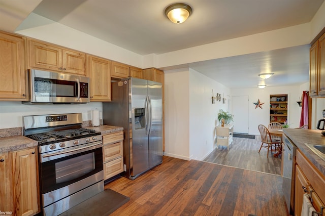 kitchen with dark wood-type flooring, baseboards, and appliances with stainless steel finishes