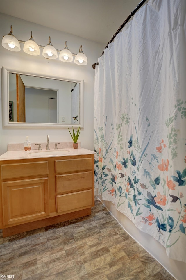 bathroom featuring shower / bath combo with shower curtain and vanity