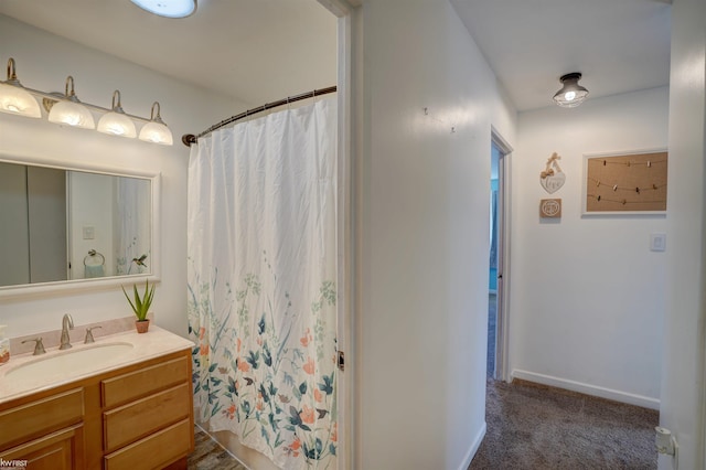 bathroom featuring vanity, curtained shower, and baseboards